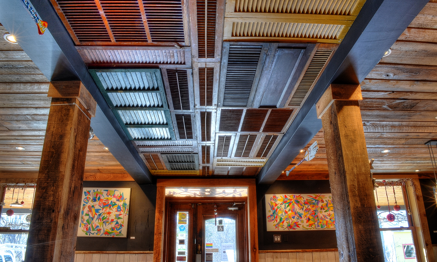 Entrée d'un restaurant avec un plafond composé d'un montage de vollets.