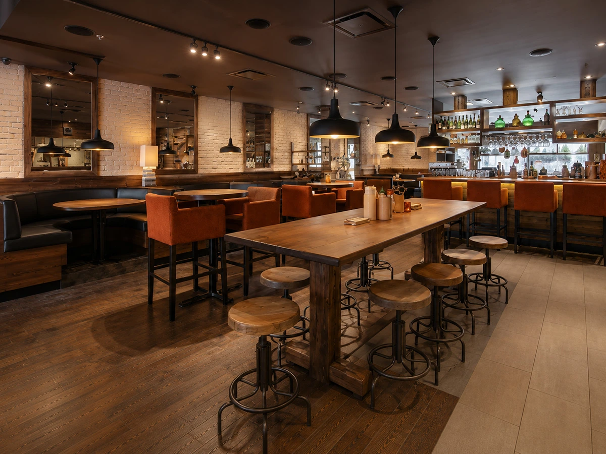 Aménagement intérieur du restaurant Sésame à Boucherville : tables communes en bois, banquettes en cuir noir et chaises orange, design par Dany Perron.