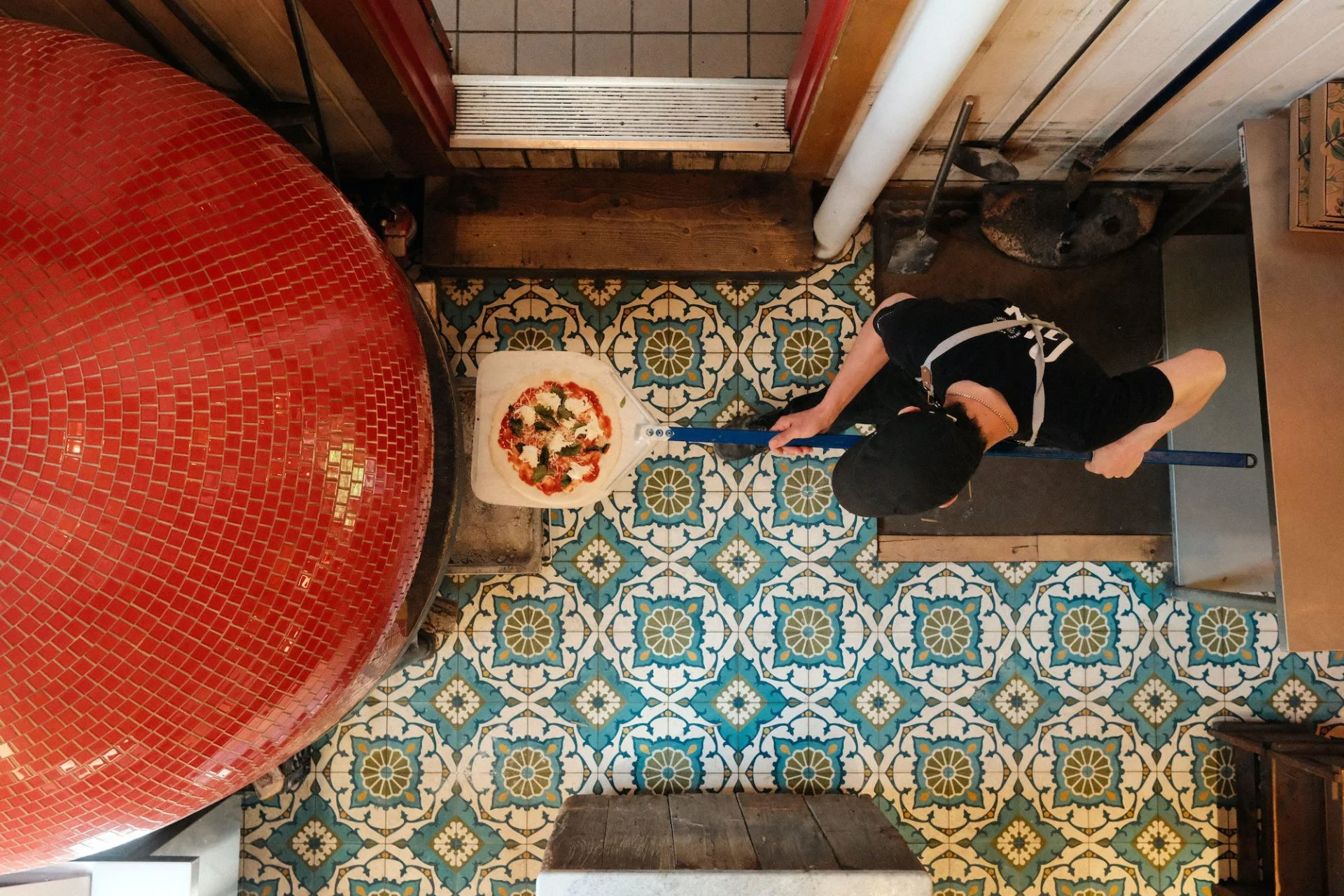 Design de cuisine avec four à pizza artisanal et carrelage décoratif chez Biscotti & Cie à Chelsea, aménagement par Dany Perron