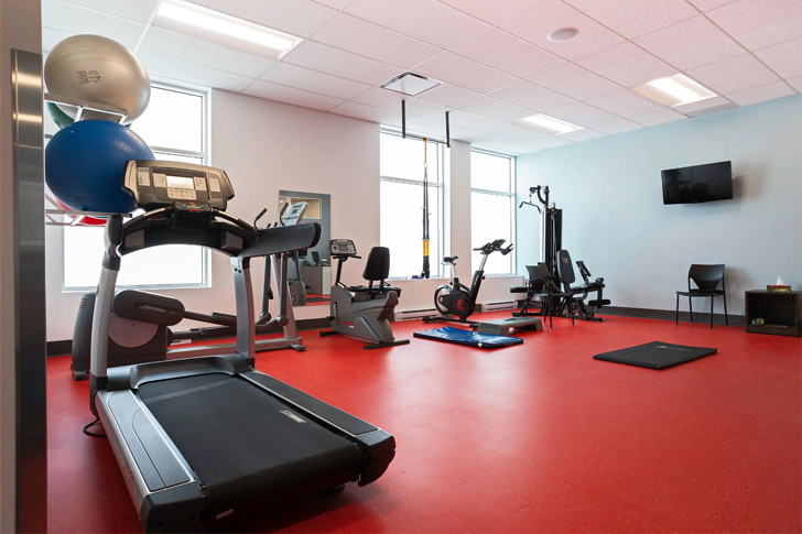 salle de gym tres lumineuse avec un plancher rouge