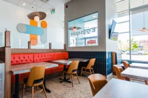 Aménagement de restaurant avec banquette orange et luminaire décoratif scandinave - Projet finalisé par DP Designer. Dany Perron