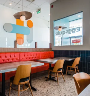 Aménagement de restaurant avec banquette orange et luminaire décoratif scandinave - Projet finalisé par DP Designer. Dany Perron