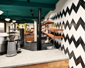Station barista professionnelle avec moulin cafe, comptoir beton blanc, mur accent chevron noir blanc gris, etageres bois flottantes, plafond vert emeraude