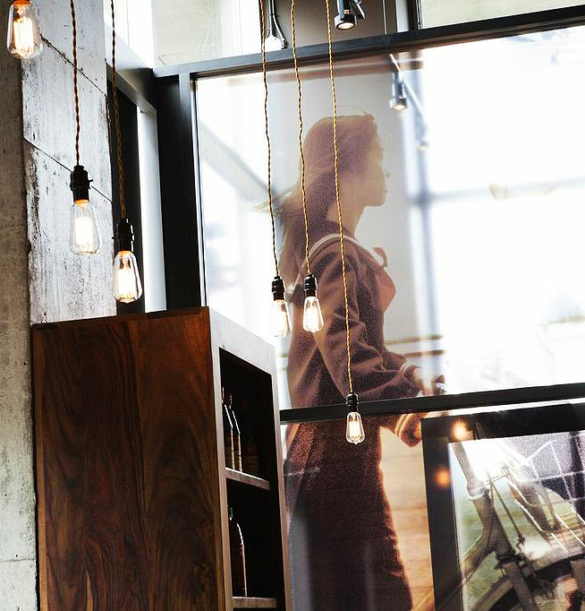 Fenestration pleine hauteur avec impression d'une image signature et éclairage suspendu dans le restaurant Sésame à Montréal.