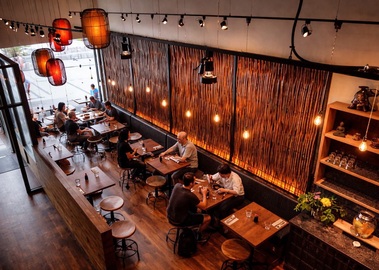 Salle à manger du restaurant Sésame à Montréal avec luminaires d’inspiration orientale, mur de bois narurette rétro-éclairer, grande façade ouverte