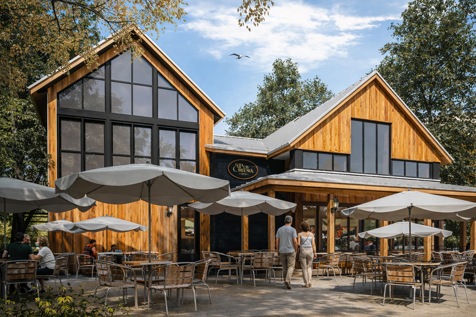 Un café moderne en bois avec de grandes fenêtres et des places assises à l'extérieur. Plusieurs tables avec des parasols sont installées à l'extérieur. Deux personnes se dirigent vers l'entrée du café et des arbres entourent l'endroit sous un ciel partiellement nuageux.